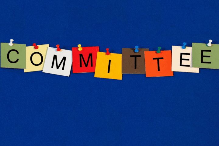 A blue background with the word committee written in colorful letters.